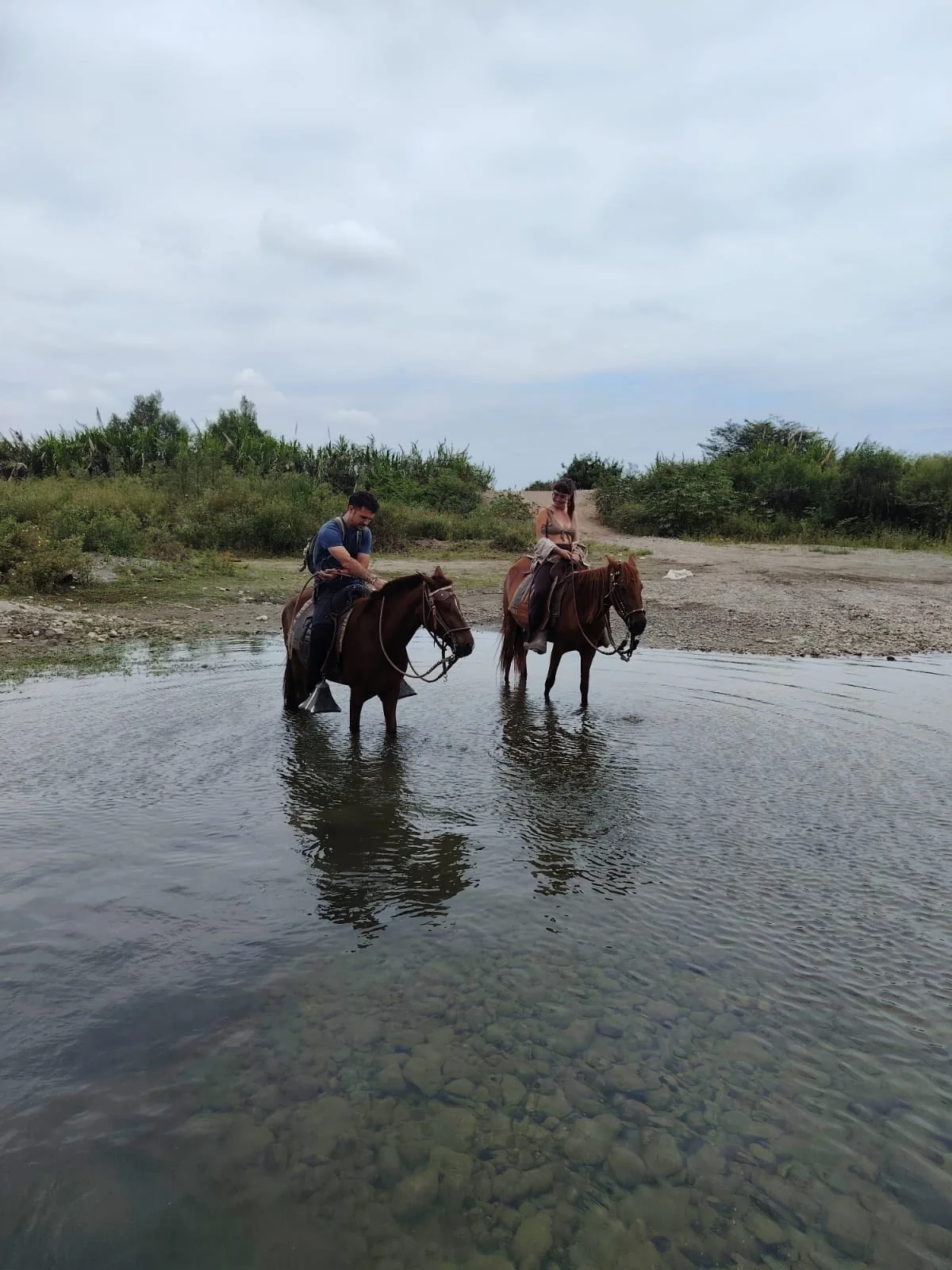 Jinetes cruzando agua poco profunda en Jequetepeque
